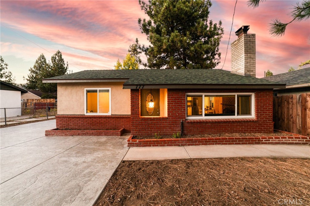 Welcome to this charming Big Bear cottage — a turnkey mountain retreat with a spacious driveway, detached two-car garage, and potential RV parking. Perfect as a cozy getaway or short-term rental, this home is ideally located in Big Bear City, just minutes from Big Bear Lake, Big Bear Airport, Bear Mountain Ski Resort, the Big Bear Convention Center, popular local dining, and convenient access to Highways 38 and 18. Inside, you’ll find a warm and inviting atmosphere featuring wood floors, a cozy fireplace/hearth, and an updated kitchen with modern finishes. The home includes an indoor washer and dryer, vinyl windows, freshly painted interiors, and an updated bathroom. All appliances and furnishings are included, making this a truly move-in-ready opportunity. Enjoy the peaceful outdoor setting on the private rear patio, complete with market lighting and surrounded by tall pine trees — the perfect spot to relax and take in the mountain air. Don’t miss your chance to see this attractive Big Bear cottage — it’s everything you need for your next home or investment in the mountains!