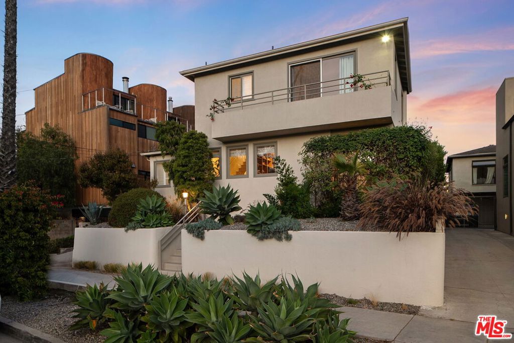 Situated on a hilltop, 626 Pacific Street offers a rare chance to own a compound in Ocean Park with a single family home and a permitted guesthouse on a single lot. Just six blocks from the beach, this property enjoys cool ocean breezes and open-sky views from its balconies. The main residence features maple hardwood floors and a kitchen with Brazilian quartzite counters and integrated appliances. The primary bedroom upstairs is light and bright and offers mountain views and peek-a-boo ocean glimpses, leading to a private deck perfect for relaxation. Throughout the property, there are various cozy spots for dining, enjoying a drink, gardening, or soaking in the hot tub. Adjacent to the outdoor patio area, the two-car garage is being utilized as a flexible space, great for an office, gym, or playroom, complete with a bath and laundry. The spacious yard, with its mature fruit trees and herb garden, adds to the property's appeal. The second home, a welcoming guesthouse, features a quaint front porch, a full kitchen, living area, one bedroom, a bath, and a private patio, making it ideal for guests or as a rental option. With four bedrooms and four bathrooms across both homes, this compound offers flexibility, ample indoor/outdoor living, and prime access to Main Street, the beach, and the unique lifestyle of Santa Monica.