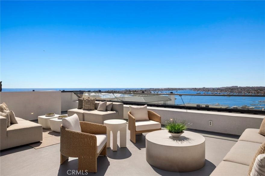 A Rare Coastal Masterpiece in the Heart of Corona del Mar Village. A true rarity in coastal living, this newly constructed residence blends exceptional design, craftsmanship, and location into a singular offering. Situated on an expansive 45-foot-wide lot, the home features 4 bedrooms and 4.5 baths across three meticulously crafted levels—each accessible via private elevator. Born from a remarkable collaboration between DeCarrier Design, Montesantos Builders, and Teale Architecture, every element of this home reflects an uncompromising attention to detail and a level of quality reserved for the most discerning buyers. The primary suite serves as a private sanctuary, offering a luxurious retreat with a spa-inspired bath featuring an oversized steam shower, a soaking tub with calming water views, and a dual-sided fireplace that warms both the bedroom and bathroom. Each of the four ensuite bedrooms has been thoughtfully designed to offer privacy and comfort. Floor-to-ceiling retractable glass doors reveal sweeping views of the harbor and ocean, effortlessly merging indoor and outdoor living. At the heart of the home, the chef’s kitchen showcases elevated function and design—with a dramatic quartzite-wrapped island, oversized Sub-Zero refrigerator and freezer, Wolf range, walk-in pantry, wine storage, and a built-in Miele coffee system. Crowning the home is an expansive rooftop deck with panoramic views of the ocean, harbor, and city lights—an ideal setting for both relaxed lounging and elegant entertaining. Located just one block from the beach and a short walk to the Village’s celebrated shops, cafes, and restaurants, this residence is more than a home—it’s a statement of timeless luxury and coastal sophistication. A true legacy property that sets a new benchmark in Corona del Mar.