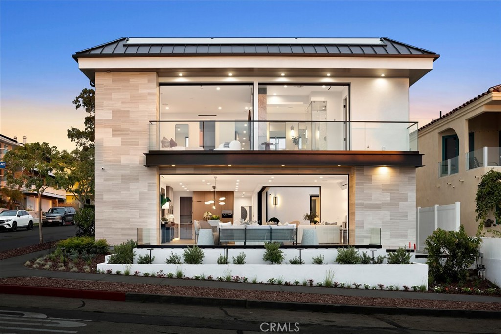 A Rare Coastal Masterpiece in the Heart of Corona del Mar Village. A true rarity in coastal living, this newly constructed residence blends exceptional design, craftsmanship, and location into a singular offering. Situated on an expansive 45-foot-wide lot, the home features 4 bedrooms and 4.5 baths across three meticulously crafted levels—each accessible via private elevator. Born from a remarkable collaboration between DeCarrier Design, Montesantos Builders, and Teale Architecture, every element of this home reflects an uncompromising attention to detail and a level of quality reserved for the most discerning buyers. The primary suite serves as a private sanctuary, offering a luxurious retreat with a spa-inspired bath featuring an oversized steam shower, a soaking tub with calming water views, and a dual-sided fireplace that warms both the bedroom and bathroom. Each of the four ensuite bedrooms has been thoughtfully designed to offer privacy and comfort. Floor-to-ceiling retractable glass doors reveal sweeping views of the harbor and ocean, effortlessly merging indoor and outdoor living. At the heart of the home, the chef’s kitchen showcases elevated function and design—with a dramatic quartzite-wrapped island, oversized Sub-Zero refrigerator and freezer, Wolf range, walk-in pantry, wine storage, and a built-in Miele coffee system. Crowning the home is an expansive rooftop deck with panoramic views of the ocean, harbor, and city lights—an ideal setting for both relaxed lounging and elegant entertaining. Located just one block from the beach and a short walk to the Village’s celebrated shops, cafes, and restaurants, this residence is more than a home—it’s a statement of timeless luxury and coastal sophistication. A true legacy property that sets a new benchmark in Corona del Mar.