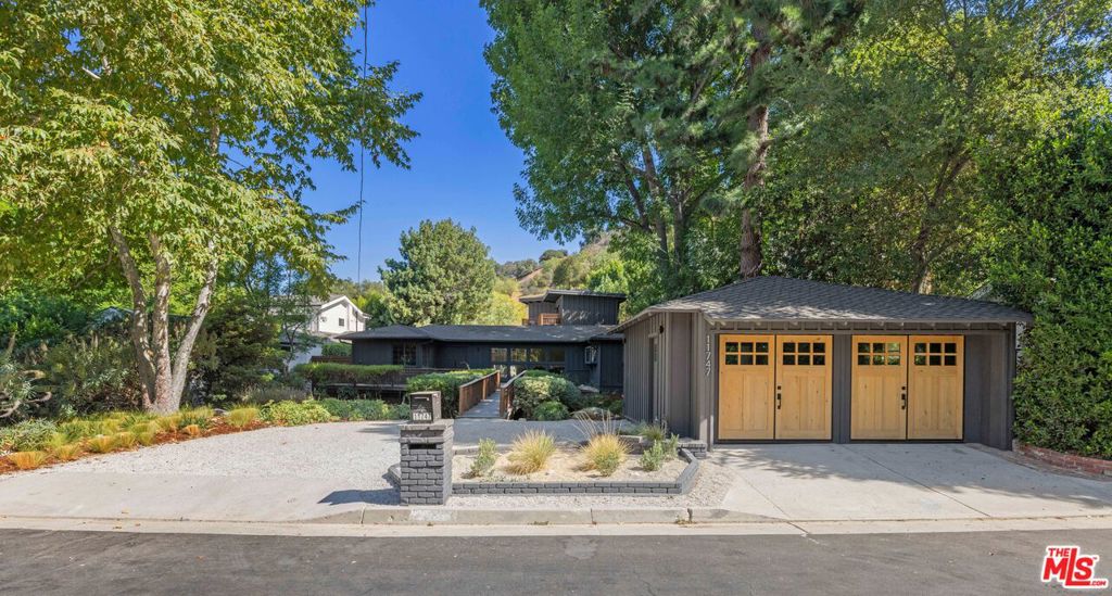 Step into your own private sanctuary in the highly sought-after Carpenter School District! This beautifully remodeled 4-bedroom, 3-bathroom home features an additional 1-bedroom, 1-bathroom guest house and a finished garage flex space, perfect as a gym, office, or creative studio. From the moment you arrive, the property sets a magical tone, surrounded by serene gardens and towering trees. You'll cross a charming little bridge to reach the front doors, where the home's character begins to unfold. Inside, every detail has been thoughtfully designed. Lime-washed walls create a timeless, organic feel, complemented by engineered hardwood floors throughout. The living room features stunning floor-to-ceiling windows that flood the space with natural light, creating an airy, uplifting atmosphere. The chef's kitchen boasts custom cabinetry and marble counters, with a charming breakfast nook tucked in the corner. Each bedroom has been meticulously designed, with none sharing walls, offering ultimate privacy for everyone in the family. The luxurious primary suite includes a private patio overlooking the gardens, a beautiful custom vanity, a soaker tub, and an oversized walk-in shower. The guest house offers a spacious living room with a cozy fireplace, plus a separate bedroom complete with a walk-in closet and full bath - ideal for visitors, extended family, or a private home office. Outdoors, the thoughtfully landscaped grounds provide a completely private retreat, ideal for relaxation or entertaining. Located just minutes from Sportsmen's Lodge and all the best shops and restaurants along Ventura Boulevard, this home perfectly blends an idyllic private sanctuary with unmatched convenience.