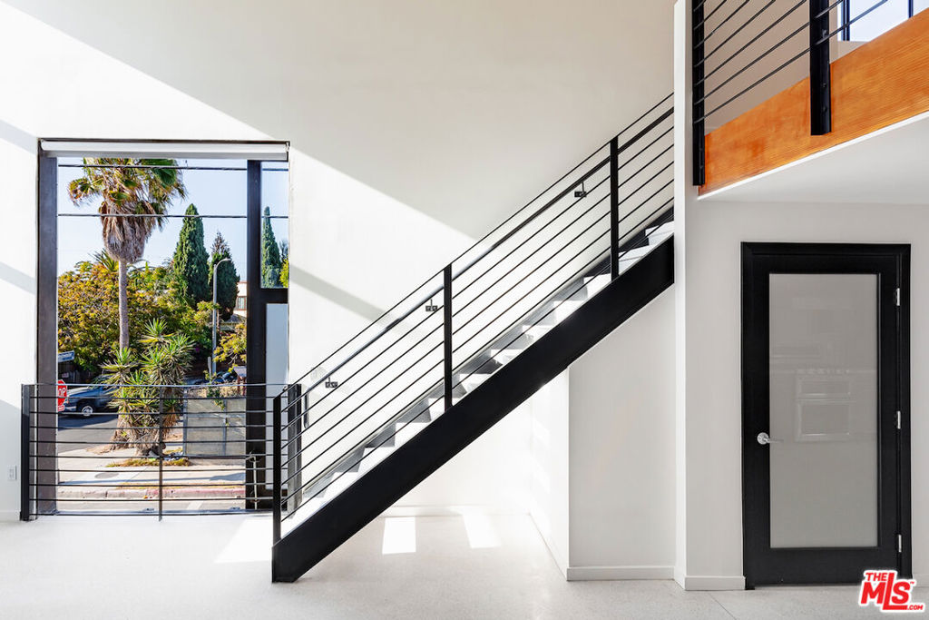 A perfect office alternative or residence; this one-of-a-kind architectural live-work loft, steps to Abbot Kinney Blvd nightlife and shopping. A light-filled corner unit that offers a townhouse style walk up with private 2-car parking garage, a balcony and a roof deck with 360 views, an open floor plan with 20-foot ceilings and automated smart home features. Divine northern exposure lighting throughout and a fresh ocean air breeze from the living room's industrial sliding door. The covered balcony adjoins both the dining area and modern kitchen w/ Caesarstone countertops, walnut cabinetry, under cabinet lights and stainless appliances. Upstairs is the large sleeping area loft which has extra office/flex space and custom wardrobe closet off the main bathroom. The interior features an additional half-bath, white Terrazzo flooring, automated home lighting, Nest video doorbell/thermostat, motorized black out window coverings, in unit laundry area with washer/dryer, storage & FCFS guest/community parking. Large roof deck space with 360 degree views of city lights from the ocean to Hollywood. This is a rare offering in one of the most sought after Abbot Kinney art loft buildings.