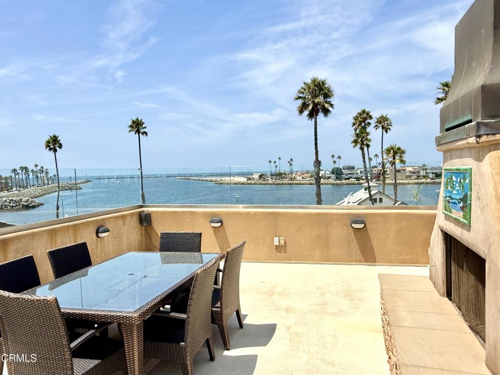 Discover your private Shangri-La at the entrance to Channel Islands Beach & Harbor--where luxury living meets panoramic ocean, island, and sunset views.This extraordinary 4-level beach home is a masterpiece of design and craftsmanship, offering captivating views from nearly every room and multiple outdoor decks on the 2nd, 3rd, and 4th level.Built with meticulous attention to detail, the home showcases natural stone flooring, solid knotty Alder wood cabinetry and doors, and a grand Brazilian Mahogany staircase that elevates the home's coastal elegance.The first level features a private guest quarters with its own entrance, guest bedroom & bath plus family room, wet-bar, laundry area, ideal for visitors or multigenerational living.On the second floor, soak in even more coastal views from the family room and step out to a view deck with ocean breezes. Entertain with ease at the built-in wet bar or unwind in the spacious guest bedroom and full bath. The primary suite offers tranquil harbor views and a spa-like en-suite bath with an oversized walk-in shower, jetted tub, and double vanity.An elevator provides effortless access to all floors, including the third level, where the home truly shines. Soaring custom wood beam ceilings, dramatic ocean views, and a stunning open-concept living space await. The gourmet kitchen is fitted with Viking Professional stainless appliances and striking granite countertops. The living area, complete with fireplace, flows seamlessly to an expansive wraparound deck--perfect for entertaining or relaxing by the sea.Crowning the home is the fourth-floor rooftop deck, offering 180 views of the beach, harbor, islands and marina. Complete with an outdoor fireplace, built-in BBQ, and refrigerator, this is the ultimate setting for sunset soirees or your own private sky lounge. This view location is a rare opportunity to own a legacy coastal property blending luxury, design, and the very best of beachside living.
