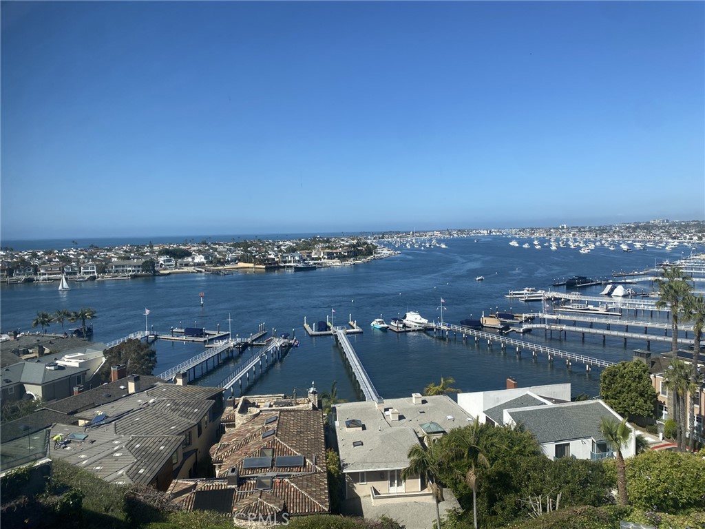 Stunning 2025 complete remodel with high-end luxury in mind. Indulge in awe-inspiring panoramic views of Newport Harbor, Catalina Island, city lights, and the California coastline. The contrast of the majestic white-water scenery against the coastal landscape creates a truly remarkable masterpiece that showcases the exceptional value and uniqueness of this home. Entering through a custom front door you’re greeted with a downstairs private office / or extra guest 3rd bedroom as well as a dramatic glass staircase that leads you upstairs to a residence that is expertly designed for sophisticated entertaining, with a captivating view of Newport Harbor. No detail has been overlooked, the newly remodeled home includes a remodeled kitchen that highlights built-in beautiful custom oak cabinets, X-Tone countertops, backsplash, and breakfast bar center island, 6-burner Viking range/oven, top-of-the-line Sub-Zero refrigeration system, microwave drawer, dishwasher, and a walk-in pantry. Off of the kitchen is the beautiful dining area surrounded by a wall of windows and skylights allowing in lots of natural sunlight. The master suite includes a private balcony and boasts two spacious closets with one being a walk-in closet. The completely remodeled master bathroom offers dual sinks, custom lux cabinets, designer light fixtures, a soaking tub for ultimate relaxation, and an oversized shower inlayed with sleek Italian made tiles. The secondary bedroom includes a custom built-in closet with plenty of storage space and is located across from the secondary bathroom that includes custom Lux cabinets, modern light fixtures, and a glass enclosed shower with sleek modern tiles. The main showpiece in this incredible home is the family room that showcases a X-tone stone fireplace and entertainment wall, floor to ceiling glass windows with a captivating Harbor View as well as a private patio where you can sit and enjoy the morning sunrise and an evening sunset. Additional features include Prima Lusso hardwood floors throughout, all new LED lighting, inside laundry, designer light fixtures, custom doors throughout, built-in custom closet cabinets, new metal roof, new exterior remodel, new garage door, one car garage with spec flooring, and an additional driveway parking space. This property is the only residence on the street with a full backyard/patio with plenty of space including a fountain, fireplace, and BBQ area overlooking the bay.