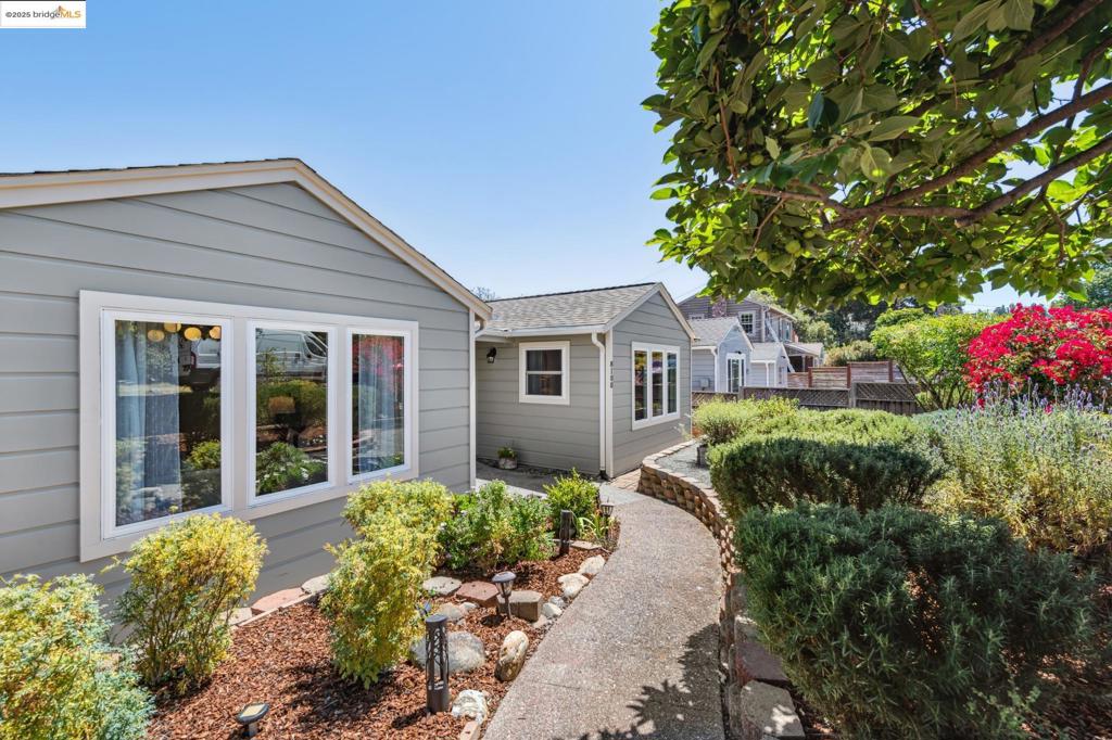 Garden lovers, this spacious 1454 sq ft Oakland Hills cottage is calling! Set on an on a expansive 5,000 sq ft corner lot, the terraced front yard bursts with fruit trees, raised vegetable beds, and colorful landscaping. Inside, find three bedrooms—including a large private primary ensuite—plus beautiful hardwood floors. The living room offers garden views, a wood-burning fireplace, and an adjoining dining area. The kitchen features granite counters and a sunny breakfast nook overlooking the backyard. Bathrooms are stylishly updated with tiled shower surrounds. A dedicated laundry room, private deck and versatile finished shed, perfect for an office or gym, complete the picture. Enjoy quick I-580 access for an easy commute.