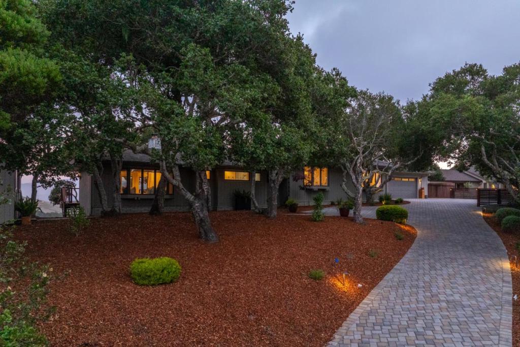 Sophisticated comfort with stunning views. Tucked on a private lane in sunny mid-valley and located in the coveted Carmel School District. This remodeled 3-bed, 3-bath single-story home offers effortless living and entertaining. The open layout includes spacious living, family, and dining areas that flow into a modern kitchen, all filled with natural light from walls of windows. Enjoy the ease of single-story living, two cozy fireplaces, and expansive decks with a fire pit, hot tub, and 180° views of vineyards, Garland Park, Big Sur and Carmel Valley Ranch. A sunny detached art studio or flexible office space adds even more versatility. Upgraded throughout this home is a must see.