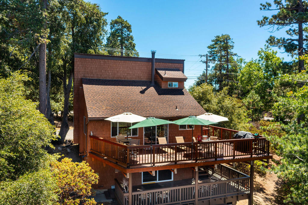 Paradise Pines Retreat - Views, Views & More Views! Welcome to this extraordinary mountain getaway, lovingly maintained and designed for carefree living. Set on two side-by-side lots totaling nearly 1/2 acre, this retreat offers space inside and out to relax, entertain, and soak in its breathtaking location. The main level features a spacious bedroom and full bath, along with an inviting kitchen, dining, and living area accented by warm vinyl flooring and rustic wood ceilings. Upstairs, you'll find a light-filled sleeping loft with half bath and laundry, plus an additional guest bedroom. Skylights keep the cabin bright in summer and cozy in winter. A private studio apartment with its own entrance sits on the lower level, ideal for overflow guests or rental income potential. The true highlight? Stunning sunset views from the upper deck, as well as from the home's interior living spaces. A circular driveway provides ample parking, and you're just minutes from the Village of Idyllwild's shops, restaurants, and hiking trails.