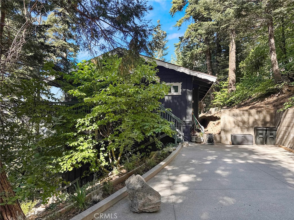 Charming mountain retreat with lake and mountain views! This Crestline gem offers plentiful parking, level access, and just a couple of steps to the front door. Tucked back from the road for privacy, the home is surrounded by a woodsy setting with no houses behind. Relax on the expansive back deck and take in serene views of the lake and mountains. Perfect for entertaining, the open floor plan features a spacious kitchen with a breakfast bar that flows into the dining and living rooms. Enjoy tall beamed ceilings, a cozy gas fireplace, and beautiful solid wood floors. The main level includes a remodeled bathroom and bedroom, while the lower level offers three additional bedrooms and another remodeled bath. Additional highlights include upgraded double-pane windows, Quartz counters, ample storage, and stunning lake views from multiple rooms. Live like you’re on vacation year-round in this resort-style community—Lake Gregory offers a water park, boat rentals, fishing, scenic hiking trails, and even a dog park.