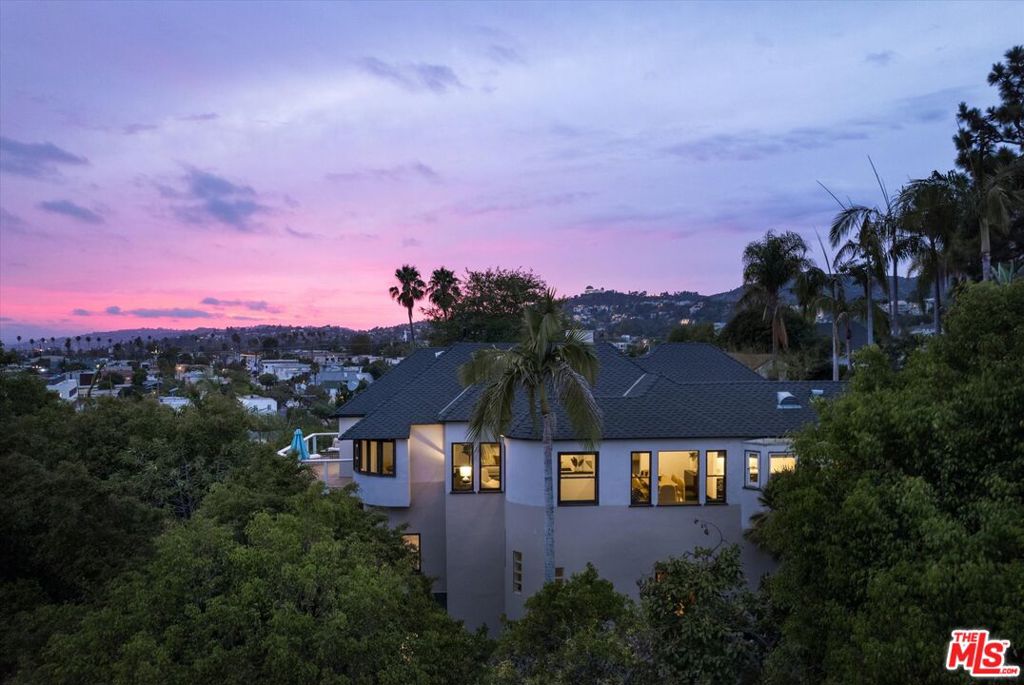 A contemporary Spanish with gorgeous views in the sought after Franklin Hills of Los Feliz. On a quiet, neighborly street, enter into a private tiled front courtyard with a bubbling fountain and garden pathways. This well cared for 3480 sq ft residence is bathed in natural light, with wraparound windows offering peaceful treetop, hillside and city views from day to night. In the main level, a spacious living area offers dual seating areas and access to the large southwest facing balcony. Gorgeous formal dining room features views of the downtown LA skyline amidst hillside vistas. A large galley style kitchen includes a Wolf range, premium built-in appliances, Caesarstone countertops and custom cabinets with rack for wine bottles and a breakfast nook, also with views. The primary suite bedroom offers tiled bath, large dual closets and direct access to the view balcony. Two additional guest bedrooms and hall bathroom complete the main level. Step into another separate level of the home to experience substantial additional space for work, entertainment, and hosting guests. A large library with a full wall of built-in bookshelves, vaulted ceilings and cedarwood walk-in closet, is a perfect place to work from home or study. The media room offers lots of seating for movie nights, with an adjacent kitchenette/wet bar. An additional lofted fourth bedroom features views into the garden below. A full bathroom and gym/wellness space complete the home's spacious floor plan. A lower balcony with built-in seating overlooks the manicured yard space, with mature palm trees, fruit trees, grapevines, multiple patios and a peaceful gazebo retreat. There is ample room for gardening, pets, outdoor enjoyment and space for hosting large events or family gatherings. Zoned to Franklin Elementary, this wonderful neighborhood offers proximity to the best of Los Feliz including the Village, Griffith Park and shopping and restaurants along nearby Hillhurst and Hyperion Avenues. Showing Remarks: Private showing: Please contact listing agent: Courtney Pickard at (719-248-4825)