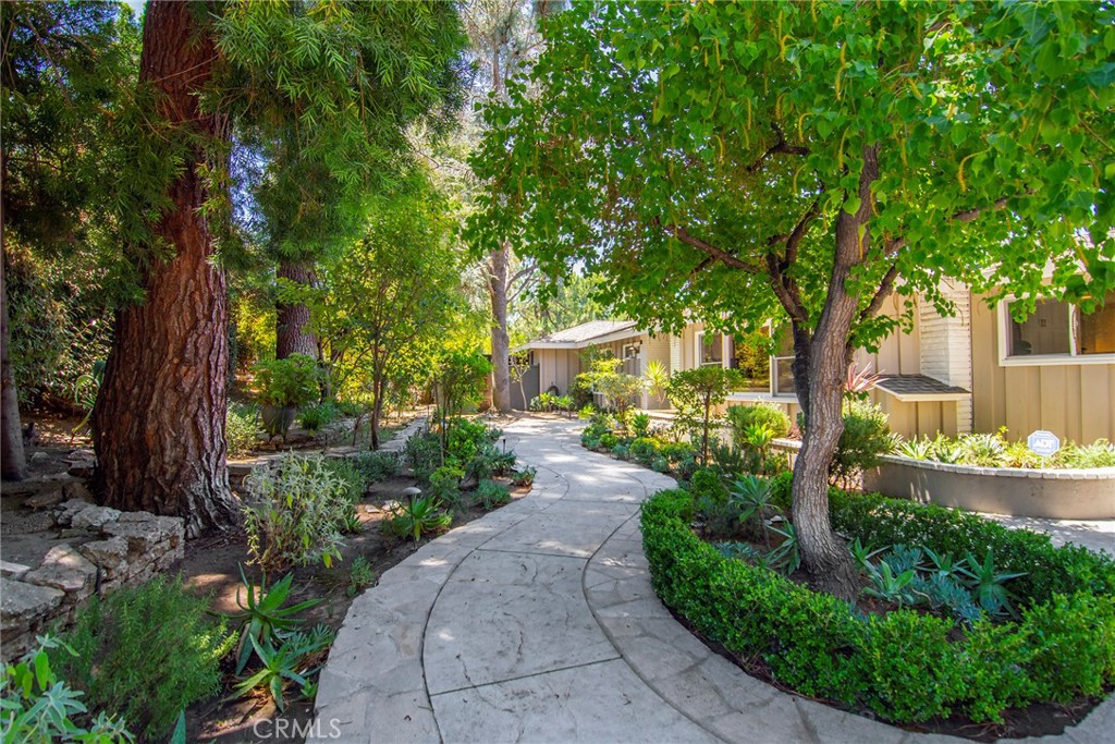 With this one, be prepared to take the leap, as this may very well be your treasured home for a lifetime. Extraordinary beyond words & once experienced, you’ll never want to let go. Situated on a sprawling nearly 1/2 acre magical lot at the end of a tranquil cul-de-sac where a gated entrance welcomes you with open arms. Exquisite professional landscaping, lush foliage & majestic trees create this mesmerizing woodsy environment. Inside, all the warmth & charm within this light & bright single-level ranch is truly captivating. Gorgeous hardwood flooring & A-framed wood beamed ceilings make a lasting first impression. Living rm enjoys a cozy fireplace, custom built-in & large windows to devour the tranquil backdrop. A distinct brick fireplace defines the family rm/dining area & the open kitchen, which oversees all, affords beautiful cabinetry, quartz counters, six-burner wolf range, & an ideal breakfast nook. The huge primary suite is a private haven within. Soaring A-framed ceilings, sitting/office area, his/her walk-in closets, 2 glass doors to access the rear & large skylights. An escape within the escape is this ultra-luxurious primary bath enhanced by unique architectural ceiling accents, a sizable rain-head shower, striking custom tile work & a cherished soaking tub masterfully positioned beneath a large bay window to harness the serenity the exterior natural splendor inspires. 2 of the 3 additional bedrooms are ensuites with beautifully upgraded baths & the front bedroom adjoins a stunning hall bath. Outside, the love brewing from what you’ve already witnessed will now be become so deep, it just may haunt you forever should you let it slip away. This spectacular private rear yard goes well beyond anything you’ve been yearning for. Enjoy covered dining/entertaining with an outdoor fireplace. An incredible side section offers a story-book tree house where a collection of childhood memories await creation. A massive newly plastered pool/spa features a large baja step. Stunning wood deck, fireside conversation arena, outdoor shower & yet another incredible section at the western edge completes these sacred grounds. Within the garage, a room with heat/air & adjoining bath can be utilized as an office, studio, gym or more. Why travel to a distant forest to renew and reconnect with nature when you can reside within your very own each & every day. Truly an incredible house on an incredible street with sought-after schools too. Miss this & you’ll be so sorry!