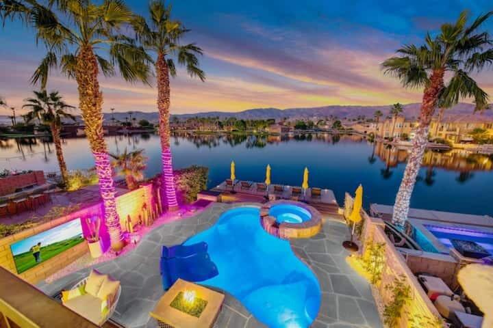 Stunning Lakefront Luxury Home with $300K+ in Upgrades | Largest Dock on the Lake | Successful STR IncomeWelcome to a truly rare offering in the highly sought-after Terra Lago community of Indio, California - the City of Festivals. This exquisite lakefront residence boasts over $300,000 in recent upgrades, no homes directly in front, and unparalleled views of the lake, surrounding mountains, and the European-style bridge.One of the home's most unique features is its expanded dock - the largest on the lake. Originally granted only to the first homes built, this rare addition extends outdoor living by nearly 5 feet, a benefit no longer permitted, making it truly one-of-a-kind.Step outside to your resort-style backyard oasis, complete with a sparkling pool, spa, multiple lounge areas, custom BBQ kitchen, firepit, and a massive weatherproof outdoor TV. Foggers in the pool, misters throughout the patio, and cool-decking ensure ultimate comfort even on the warmest desert days. At night, enjoy the ambient lighting that transforms the space into a private retreat.Inside, every detail exudes elegance. The chef's kitchen rivals the finest in design and function, complemented by Italian marble flooring throughout. The dining room showcases a dazzling Swarovski chandelier, and all designer furnishings are included in the sale. A custom glass staircase railing and striking chandelier set the tone as you move upstairs to the custom arcade/game room.The primary suite is both chic and serene, complete with an adjacent nursery and a spa-inspired bathroom featuring marble finishes, a freestanding soaking tub, dual showers (one with a custom steam room), and access to a private balcony with breathtaking views. The additional bedrooms are equally stylish, offering thoughtful touches for family and guests.This home is not only a luxurious retreat but also a proven income-producing asset. In 2024 it generated $140,000 in gross STR revenue, and it has already surpassed $100,000 in 2025 (per management company records). With no rental restrictions in Terra Lago, it's an ideal opportunity for investors seeking a 1031 exchange or buyers looking to enjoy passive income.Located minutes from the world-renowned Coachella and Stagecoach Festivals, Terra Lago continues to thrive as the Coachella Valley expands, with the airport set to double in gates to handle record-breaking visitor traffic.