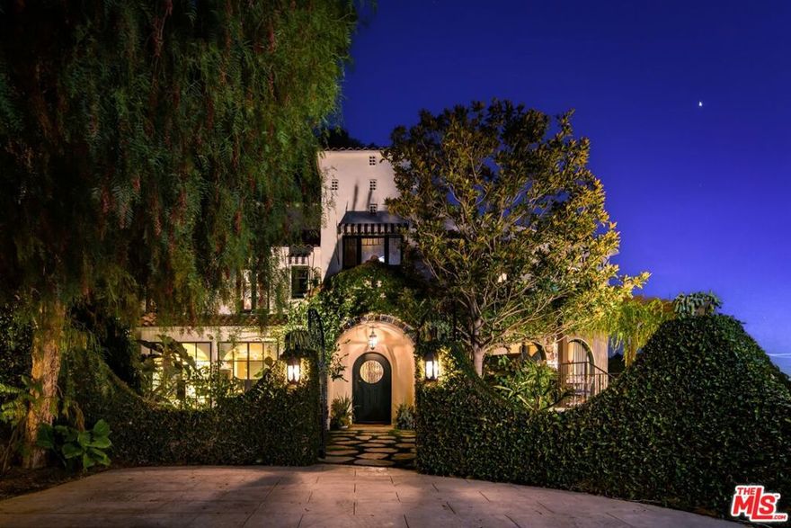 Perched above the Sunset Strip on an extremely private promontory with stunning city views from DTLA to Century City, this iconic Spanish estate is located down a long private driveway behind two security gates. This one-of-a-kind home has been restored and renovated with the finest and most stunning finishes with a slightly modern edge. The grand courtyard entry reveals a stunning living room with chevron patterned reclaimed French oak floors, and custom arched steel doors that showcase the breathtaking city view. Chef's kitchen is equipped with Officine Gullo Appliances, custom cabinetry, and a spacious dining area. Primary bedroom suite has an amazing custom closet and a walnut paneled, marble bathroom. Additionally, there are 3 other bedrooms and 3.5 baths, a spacious den with built-ins, a music room, and a bar room styled after a speakeasy with doors that open to a patio leading out to the pool. The pool and spa, grassy area with fountain, outdoor kitchen and dining pergola make up the outdoors along with two-car covered parking. True privacy, Authentic Spanish architecture in an easily accessible location come together for this unforgettable, one-of-a-kind home that makes you feel like you are in the south of France.