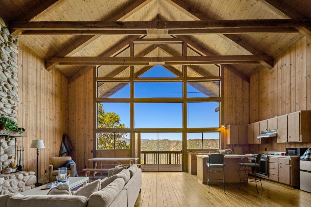 Discover a rare opportunity to own a private sanctuary designed for the discerning outdoor enthusiast. Nestled on 100 pristine acres, this exquisite cabin offers commanding, unobstructed views of the Los Padres National Forest and Los Padres Reservoir, an awe-inspiring backdrop. The cabin features a dramatic vaulted ceiling and floor-to-ceiling windows that flood the interior with natural light and perfectly frame the breathtaking scenery. A grand river rock fireplace anchors the living space, creating a warm and inviting atmosphere. The two loft bedrooms feel like you're perched sleeping on top of the world. An expansive deck is ideal for alfresco dining, stargazing, and sunset soirees all set against the serene natural landscape. Enjoy access to nearby fishing and water activities, while miles of scenic dirt roads invite hiking, horseback riding, and exhilarating ATV adventures. Hunting is also possible for those seeking the full outdoor lifestyle. Private trails from the cabin to the National Forest extends your outdoor playground to 1.75 million acres. All of this is just 30 minutes is the world-class dining, wine tasting, and charm of Carmel Valley Village. It's a legacy property unlike any other.