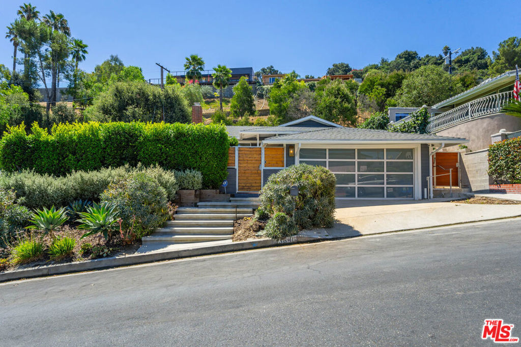 Introducing a captivating residence that seamlessly marries modern convenience with timeless charm. Unlock the door with keyless entry at both the front door and front gate, adding an extra layer of security. This stunning Studio City hills modern traditional home, nestled South of the Blvd, commands attention with its exceptional views. Boasting 3 bedrooms and 2 baths, this gated oasis offers a harmonious blend of functionality and luxury. Recently painted walls and newly painted fascia breathe new life into the property, creating a fresh and inviting atmosphere inside and out. The open floor plan encourages effortless flow between indoor and outdoor spaces. The heart of the home, a chef's connoisseur kitchen, now features a brand new Wolf stove, Bosch dishwasher, gleaming Viking appliances, quartz countertops, and a welcoming eat-in bar. Enjoy al fresco dining on two distinct patios, each with its own character. One patio, adorned with a cozy gas fire pit, sets the stage for memorable game nights against a backdrop of sweeping views that extend for miles. The expansive primary bedroom beckons with upgraded luxuries, including a spa-like bath complete with a rain shower and massage jets. Oversized windows flood the room with natural light and frame beautiful views. Connecting to the lush back patio, the bathroom reveals a sun-drenched green-space hill. Beyond the aesthetic delights, this home is packed with modern upgrades: wired internet networking throughout every room, security cameras (including Ring doorbell), newly added polyurea flooring in the garage, an upgraded smart sprinkler system, new smart outdoor lighting, and a brand new Hot Spring 6-person hot tub. A new water heater, upgraded bathroom with sleek shower doors, enhanced gutters with gutter guards, and a new crawlspace ventilation fan system further enhance comfort and efficiency. Located on a cherished cul-de-sac street, this turnkey retreat offers the best of Studio City privacy, style, and proximity to the area's finest amenities.