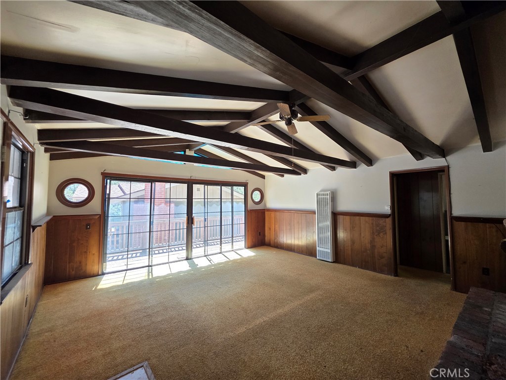 Welcome to 33007 Spruce Drive, a distinctive mountain cabin just 220 feet from the shoreline of Green Valley Lake, offering an unbeatable combination of space, setting, and potential. With rare level-entry access and off-street parking for two, the home opens into a striking great room with exposed wood trestle beam ceilings, a fireplace, and stained glass window insets that catch the afternoon light. Sliding doors lead to a spacious deck, perfect for relaxing or entertaining in the fresh mountain air. The main level also includes a bedroom and full bathroom, along with a dining and kitchen area that features a second fireplace, plentiful storage, a breakfast bar, and a dedicated room for firewood or gear. Downstairs you'll find two more bedrooms, another full bath, and a flexible bonus room complete with a kitchenette—ideal for guests, hobbies, or creating separate living quarters. While the property would benefit from updates to enhance comfort and reflect your personal style, its layout, character, and enviable location make it a compelling option in Green Valley Lake. Whether you're seeking a full-time home, weekend retreat, or investment with potential, this cabin is ready for its next chapter.