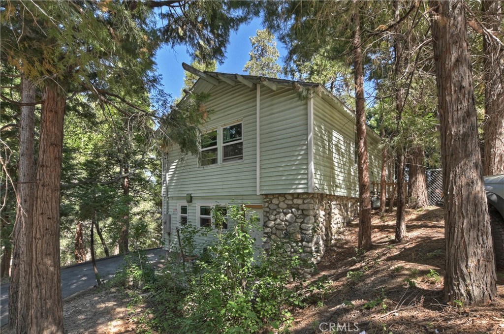 Located in the popular San Moritz neighborhood of Crestline and only minutes from Lake Gregory is this charming 3 bedroom, 1 bath home, with level entry and plenty of parking. The lower-level features stone walls and an open concept floor plan. The living room flows into the kitchen, and you will also find the bathroom on this level. The second level has two large bedrooms and a medium sized bedroom. All in all, this is a very comfortable and cozy home with pleasing curb appeal. The level backyard really stands out as a rare feature in the mountains. A privacy fence has been added, along with a chain-link fence with a gate, providing a secure area for kids or dogs to play. Crestline is a great place to live full time or part-time. You will love the local the trees and forest environment, the community events and also the quaint rural feeling that affords a break from the concrete jungle. Crestline is also within a reasonable commute time to San Bernardino, Redlands, Rancho Cucamonga and Riverside.
*Current 1/4 bathroom is a sink only. There is a place noted by the current owner's plumber to add a 1/2 bathroom and laundry hookups.