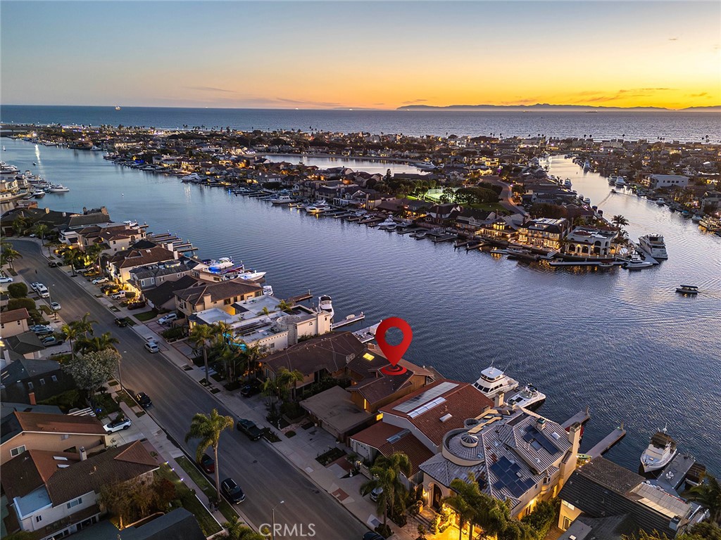 Location, Location, Location!!!  Located in one of Huntington Harbour’s most coveted Main Channel positions, this waterfront residence enjoys unrivaled multi-channel views from its premium curve setting on Humboldt Island. This property is a true blank canvas in a premier multi-million-dollar Main Channel location and offers exceptional potential for a full redesign, reimagination, or custom rebuild to maximize its world-class setting. With approximately 2,775 square feet, the home features 4 bedrooms and 3 bathrooms, including a main-level bedroom and bath. Beyond a large gated front courtyard, the entry opens to soaring ceilings, architectural brick accents, and a floating spiral staircase, all oriented toward sweeping water views. The main living spaces are designed to showcase the waterfront setting, including a living room with a classic brick fireplace and walls of glass that open to a Harbour-view sunroom. The dining room features dramatic volume and natural light, and the kitchen and breakfast area also enjoy water views.
Upstairs are three bedrooms, including the primary suite which captures breathtaking Harbour views and features wood-beamed cathedral ceilings, a fireplace, a private balcony, and an ensuite bath with walk-in shower and dual vanities. Outside, a large waterfront patio leads to an approximately 45-foot private boat dock that can accommodate two or more vessels, creating an exceptional setting for boating, entertaining, and year-round coastal enjoyment. Ideally positioned on a quiet and desirable street on Humboldt Island, the property offers convenient access to Harbour shops and dining, sandy beaches, and top-rated schools. This is a rare opportunity to unlock the full potential of a Main Channel property on one of the most desirable view corridors in Huntington Harbour, with inspection reports available upon request.