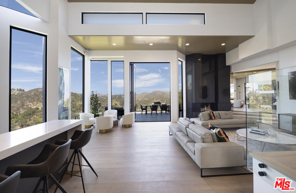 Privately tucked behind a gate, on pedigreed Bel Air Road above the prestigious East Gate, this 6,510 sq ft smart-home just underwent a massive renovation. Pulling attention up and pouring light in, unrivaled scale and volume form the perfect venue to display a collection of art. Available from nearly every vantage point, including a well-sized roof deck, an expanse of views across multiple ridgelines transforms this contemporary modern into a zen retreat. The main level is open, with several living/dining areas with fireplaces, including a wine bar and an outdoor terrace. The kitchen is equipped with ample storage and all new gourmet appliances. Take the elevator up to a giant primary suite, featuring a spa-like primary bathroom, dual closets, & patio. Next to the pool and grassy pad is a living room, wet bar, and three of the four guest bedrooms, any of which are easily converted into a home office or gym. Conveniently located to the beach, Beverly Hills, the Sunset Strip, golf, and tennis.