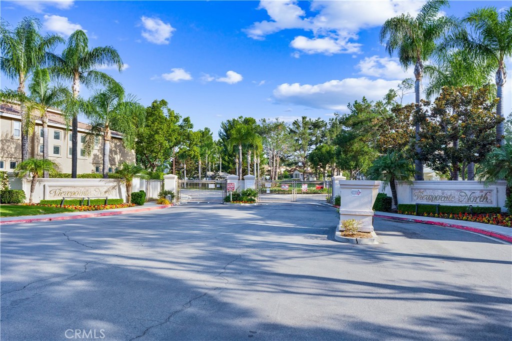 Single story, no steps, ground floor condo with a beautiful view, located in the highly desirable gated community of ViewPointe North. Backing to a peaceful greenbelt, this move-in ready home features an open layout that flows comfortably from room to room with no stairs inside. With scenic views from every room, the natural beauty of the outdoors becomes a part of everyday living. The spacious living room is filled with natural light and includes a cozy fireplace and sliding glass doors that open to a full-length patio—perfect for relaxing or entertaining. The adjacent dining area leads to a well-designed kitchen with generous cabinet space and practical functionality for everyday living. A hallway off the main living space leads to both bedrooms, providing privacy and separation from the main living areas. The primary bedroom features direct patio access, a walk-in closet, a dual-sink vanity, and an en-suite bathroom with a walk-in shower. The second bedroom is nicely sized and located near a full hallway bathroom with a shower/tub combination. A convenient indoor laundry closet is located along the same hallway. Additional features include a one-car attached garage with direct access to the home, an extra-long private driveway offering rare additional parking, and an assigned covered carport. Residents enjoy resort-style amenities including two pools, multiple spas, and a spacious clubhouse, all within close proximity to award-winning schools, local parks, Anaheim Hills Golf Course, and Walnut Canyon Reservoir.