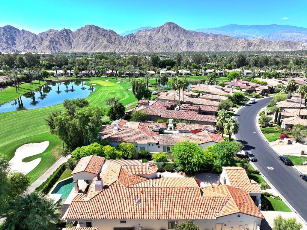 Perched on the 6th fairway of Toscana's Jack Nicklaus South Course, this home has been extensively remodeled with modern luxury and smart-home technology. Enter through a newly reimagined front courtyard with new landscaping, lighting, wrought iron entry, and Control4 security. The great room features a dramatic floor-to-ceiling quartz stone fireplace, 85'' Sony TV with surround sound, Sonos audio, and electronic blackout shades. A fully redesigned kitchen boasts Wolf/SubZero appliances, waterfall-edge stone counters, farmhouse sink, and custom cabinetry. The golf cart garage was smartly converted into a flexible office/guest room with custom cabinetry, Murphy bed, heat pump, and internet optimization--while still accommodating a golf cart. All bedrooms are ensuite, including a luxurious primary suite with custom closet, spa-like bath with dual Toto electronic toilets, and designer finishes. Outside, enjoy golf course and mountain views from a lush backyard with new landscaping, built-in BBQ, electronic awnings, fans, and Restoration Hardware furniture. Smart home, whole-house water filtration, all-new systems--this move-in ready home is the epitome of elevated desert living.
