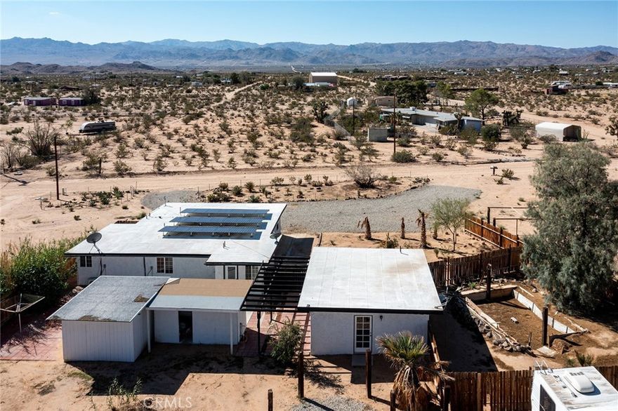 Spacious Newly Remodeled and Updated 5-Bedroom, 3-Bathroom home, including the detached, private Casita. Fully-paid solar. Work completed with Permits. Expansive 2.5-Acre parcel, bordered on the northern boundary by government-owned land providing a wilderness/privacy barrier. Views to the south of the ridgelines of Joshua Tree National Park – only a short drive away, or hike out the front door into the desert. Home has never been lived in since complete remodel, providing buyer a clean slate. Many possibilities including purchasing as a primary residence with the option to rent out the casita extra rooms to help pay the mortgage, or a long-term investment rental, or a private vacation getaway supplemented by Airbnb rentals. Includes a unfinished trailer that could act as an extra room. New ductless mini-split AC/Heaters throughout. Custom installed floor-to-ceiling tile in each bathroom. New flooring. New cabinetry and counters throughout. Clean, well-lighted integrated indoor/outdoor living, with private porch off the primary bedroom suite. Rural location, yet only minutes to downtown for dining and shopping. Perfect for a large, extended family or group purchase with friends or family to secure your desert dream.