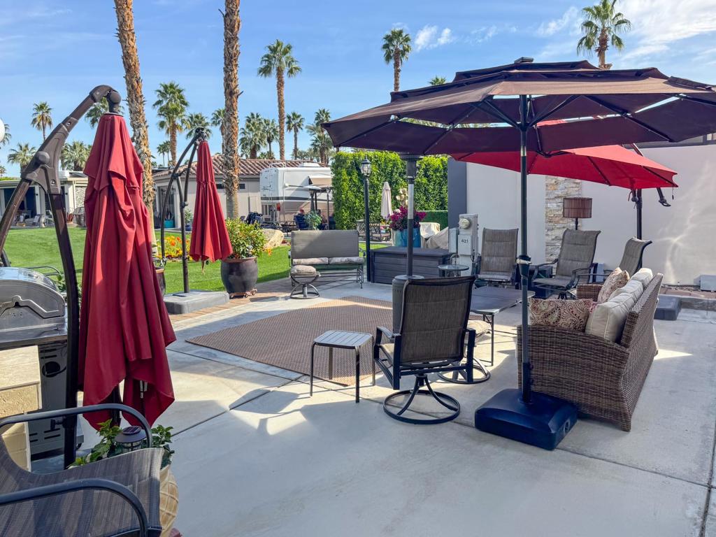 This oversized, 3,000 sq. ft. luxury RV lot is a private garden retreat with a prime east-facing rear of the lot, offering breathtaking sunrise views over the golf course and a serene park-like setting free from foot traffic. The beautifully landscaped gardens create a lush, tranquil environment with mature citrus tree, adding a refreshing touch. A large back porch extends your outdoor living space, offering a fountain view of the golf course, a perfect mix of sun and shade, and electric shades all around for privacy and comfort. From the street side, enjoy the sunset glow, making this lot an oasis for both relaxation and entertaining.The grand solid-roof pergola, featuring an insulated ceiling, three ceiling fans, and three heaters, ensures comfort at any time. The spacious outdoor kitchen, complete with granite countertops, stainless steel appliances, and an attached full-length kitchen bar, is ideal for hosting gatherings with a seamless flow of space for events. A built-in entertainment center with a TV, ample parking, and extra outdoor lighting add to the convenience and luxury of this exceptional lot. Partially furnished and assessment paid, this turn-key property is ready for you to experience premier RV resort living in style.‍Outdoor Resort Indio is a Class A only RV resort in Indio, CA.