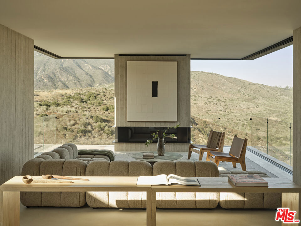 Introducing this brand new architectural masterpiece by renowned architect Christopher Sorensen and interior design by Atana Collective. Enter the home through the 15' Tesselle breeze block wall surrounded by wall-to-wall glass, creating an open yet private sanctuary. Inside, the living room is defined by its cantilevered structure where sliding glass doors disappear into board-formed concrete walls, seamlessly bringing the beauty of the natural surroundings inside. The kitchen adds rich texture to the concrete walls and floors with the cabinetry imported from italy, hand crafted italian plaster cabinets, integrated paneling with Miele appliances and equipped with an 11' kitchen island looking across to the bronze glass wine display. Continue down the light-filled hallways with floor-to-ceiling glass bordered by lush landscaping and you will find all 4 bedrooms, all of which open to the grass backyard. The primary suite features corner glass, warm oak flooring, expansive openings, and a striking board-formed concrete fireplace as its centerpiece. This property also features a detached office, multiple yard spaces with a breathtaking backdrop, including a spa-like retreat equipped with a cedar jacuzzi, sauna, and outdoor shower alongside the outdoor deck. Located in the prestigious Malibu Park area, above Zuma Beach, this home is in close proximity to Malibu High School and Middle School, Trancas Shopping Center, and numerous hiking trails connecting to the Backbone Trail. This exquisite property was built by Aksel Development, known for their custom homes and commitment to creating unique residences that harmoniously integrate into the Malibu landscape.