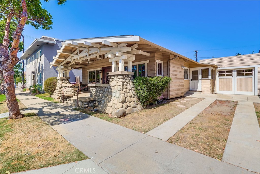 A rare gem in Long Beach's historic Willmore District! A gorgeous 1913 Craftsman home (2 bed/1 bath), with tons of original charm, PLUS all major systems updated to modern. The pictures tell the story of the living room and dining room: Beatiful wood throughout, kept nice for over 100 years. The enrty off the large stone porch welcomes you to a classic home, ready to move in, with lovely hardwood floors throughout most of the home. Beautiful stone fireplace, too (wood, and plumbed for gas). Wait until you see the funky dining room and living room lights! The kitchen has been re-done, with tasteful cabinetry, counters, and appliances, and a lovely original breakfast nook. Central air and heating, tuned-up and running great. Plumbing, electrical, windows have all been updated to modern in recent years, while maintaining the home's original charm. Large full bath with modern tasteful fixtures. Recent tune-ups on all systems, very functional and ready to enjoy. Large cellar, with access from the modest backyard. The long driveway has ample room for two cars, plus there's a very nicely fininshed 1-car garage, with direct access to the home and back yard. Fresh clean concrete, too. These homes don't come along too often, in this kind of condition! Close to Downtown LB, Coastal Areas, 710, shopping and dining options, and Convention Center. Come and get this classic Long Beach time capsule, updated and ready to go.