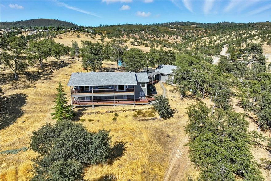 Expansive Rancho Retreat with Sweeping Views & Modern Upgrades! Set on over 5+ acres in the desirable HVL Ranchos—with no HOA dues!—this beautifully remodeled home showcases unobstructed views of the valley, Mt. St. Helena, and the Hidden Valley Lake golf course pond. With modern upgrades, thoughtful design, and versatile spaces, it’s a home that blends elegance with everyday comfort. The open great room flows into a step-down living area anchored by a wood-burning fireplace with custom stone surround. The chef’s kitchen features abundant wood cabinetry, quartz countertops, built-in oven and microwave, five-burner cooktop, and breathtaking views framed by the kitchen window. Luxury vinyl plank flooring extends throughout the home, complemented by brand-new carpet on the staircase.  Just down the hall are two bedrooms and two remodeled baths. The hall bath offers dual sinks, granite slab counters, upgraded cabinetry with linen storage, and a large tub/shower combo. The primary suite is a spa-like retreat with radiant flooring, soaking tub beneath a panoramic window, oversized custom tile shower with specialty coated glass, privacy water closet, quartz dual-sink vanity, updated lighting, and a massive walk-in closet. Also upstairs, the versatile utility room doubles as an office and laundry area with storage closets, utility sink, and breezeway access to the oversized 2-car garage with workshop. Downstairs are two additional rooms: a third bedroom with en suite bath and private deck access, plus a bonus room that is an entertainer's dream complete with custom bar, sink, cabinetry, and slider to the back deck. Both levels open to full-length covered decks, offering seamless indoor/outdoor living and panoramic vistas.  In addition to the two-car garage plus workshop, there are two attached carports, a detached RV carport, animal pens, garden areas, and plenty of space for livestock, orchards, or future expansion. Additional upgrades include an attic fan that circulates woodstove heat, a water softener, a generator at the well, and more.  A rare combination of elegance, versatility, and wide-open views—this Rancho retreat is truly one of a kind!