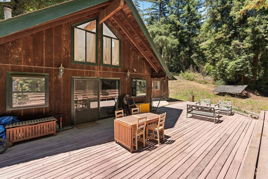 Tucked away on 11 acres of majestic redwoods, this 3-bedroom home offers peace, privacy, and natural beauty. Enjoy sweeping views from the expansive redwood deck overlooking a level front yard surrounded by gorgeous trees. A detached studio provides versatile space for guests, work, fitness, or creativity. Hidden trails lead to a stream with multiple flat, usable areas—ideal for gardening, recreation, or exploration. Designed for sustainable, off-grid living, the property features solar power, a private well, and DSL high-speed internet. Additional upgrades include a recently installed mini-split upstairs to optimize heating and cooling. Generous parking for guests is available. Located in a gated community within the Los Gatos School District and about 30 minutes from Silicon Valley, San Jose Airport, and the beaches of Santa Cruz, this mountain retreat offers rare seclusion without sacrificing convenience. Accessed via a private two-mile road—half paved, half unpaved—this property blends modern comfort with the tranquility of nature.