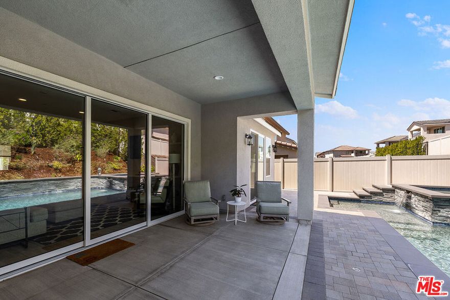 BACK ON MARKET DUE TO BUYER NOT PERFORMING. YOU HAVE ANOTHER CHANCE TO MAKE THIS HOME YOURS. When you tour this home, you will discover it is an Elevated Living experience in Santa Clarita's Coveted Skyline Community. You will step into luxury redefined in this nearly-new, meticulously designed 2023-built residence. It has 4 spacious bedrooms, a dedicated office, a versatile loft, and 2.5 bathrooms. Living in this home, you will find it is a showcase of modern elegance, thoughtful design, and ultimate comfort. You will have your Own Private Resort with total serenity in your Zen-inspired backyard retreat, complete with a custom waterfall pool, relaxing hot tub, built-in outdoor kitchen, and lush landscaping designed for maximum privacy.  The FIRST-FLOOR PRIMARY SUITE allows you to enjoy the convenience and tranquility of a main-level primary retreat, featuring a spa-like ensuite bathroom, walk-in closet, and direct access to your backyard oasis. Cooking and eating in the GOURMET CHEF'S KITCHEN, you will find it is the heart of the home which boasts stainless steel appliances, quartz countertops, rich dark shaker cabinetry, a walk-in pantry, and an oversized island ideal for everyday meals or stylish entertaining. The thoughtfully Designed Living Spaces presents an Open-concept great room with elegant dining area and cozy family space. The Custom built-in cabinetry accents the kitchen area and the bar shelving adds both style and functionality. There is a Dedicated office on the main level and an upstairs loft perfect for another office, a home gym, or media lounge. This home is also Smart & Efficient: you can live sustainably with owned solar, a fire suppression sprinkler system, and energy-efficient design throughout. There are Designer Details at Every Turn, from the dramatic iron staircase and 10 FT soaring ceilings to the premium finishes, every inch of this home reflects quality craftsmanship and modern sophistication. Whether you want to have a sunset dinner by the pool, a movie night in the loft, or a quiet morning coffee in your private yard, this home transitions effortlessly to match your lifestyle. The Skyline Community Amenities include access to a state-of-the-art fitness center, sparkling community pool, clubhouse, scenic walking trails, business center, lounge area and coffee station. The Skyline Community will build their own elementary school but it is still just minutes from top-rated schools, shopping, and dining. This community features a multipurpose field, baseball diamond, basketball court, tennis/pickleball courts, shaded playground, walking trails and panoramic hillside/mountain views. Choosing 18113 Tableau Way means you're not just buying a house, you're buying into a new, thoughtfully planned community with strong outdoor amenities, modern infrastructure, and a location that supports lifestyle, families, and long-term value. The features of this home and community contribute to making this home a compelling choice.  Seller is accepting ALL OFFERS. SUBMIT your HIGHEST and BEST today!