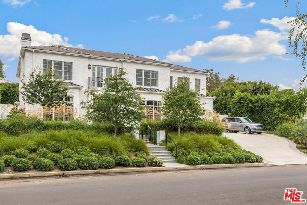 Custom white brick traditional built by Craig Williams, Vertoch Archiects and Tim Clarke interior design perched above the street in prime Riviera location. Bright transitional interior with tremendous scale, volume and taste. Stylish wallpapers, mouldings, sky lights, and wide wood plank floors. 4 bedrooms upstairs plus homework room and upstairs landing family lounge. Chef's kitchen with top of the line appliances, warming drawer, eat in marble island and wood butcher block plus separate prep kitchen with steam oven, wolf wall oven, beverage refrigerator & dishwasher. Seamless in-door out-door entertainining with sliding glass doors which open up completely to the yard. Enjoy the lap pool, spa, built-in outdoor kitchen witth bbq grill and Argentine style wood burning griil plus an outdoor fireplace, multiple sitting areas with heaters and lush landscaping creating total privacy. The Lower level of the home has high ceilings, a proper bar, temperature controlled wine room, media room/theater, fitness area, game room, gift wrapping station, large laundry room and 2 bedroom suites. There's City lights views and green tree top vistas from upstairs.