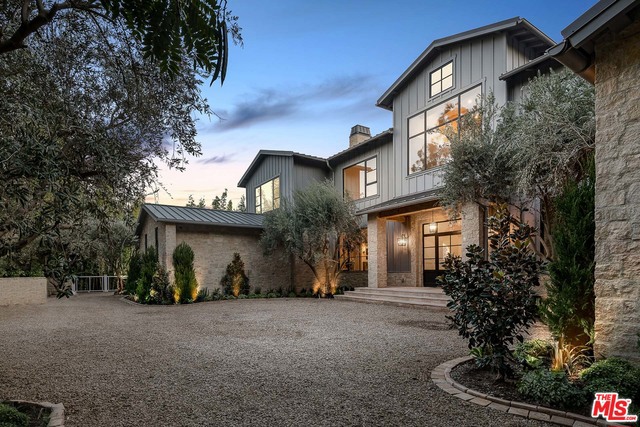 Secluded behind gates in an unrivaled Lower Mandeville Canyon setting, this Napa Valley-inspired Modern Farmhouse boasts a refined yet rustic ambiance upon an inimitable 36,000 plus square foot lot. By way of rich stone, reclaimed wood and marble features throughout, the captivating architectural seamlessly fuses contemporary details with the home's surrounding natural splendor, offering treetop and distant ocean vistas and a far-reaching equestrian-suited yard. Beyond the eight-bedroom main residence lies a covered loggia that leads out to the property's pool, spa, cabana and 924 square foot guest home, all of which are surrounded by verdant and manicured landscaping. Replete with a wine cellar, gym, elevator, media room, caterer's kitchen and spa bathroom inclusive of a dual vanity, massage room, sauna and steam room, this Philip Vertoch-designed home is the embodiment of a palatially pastoral retreat.