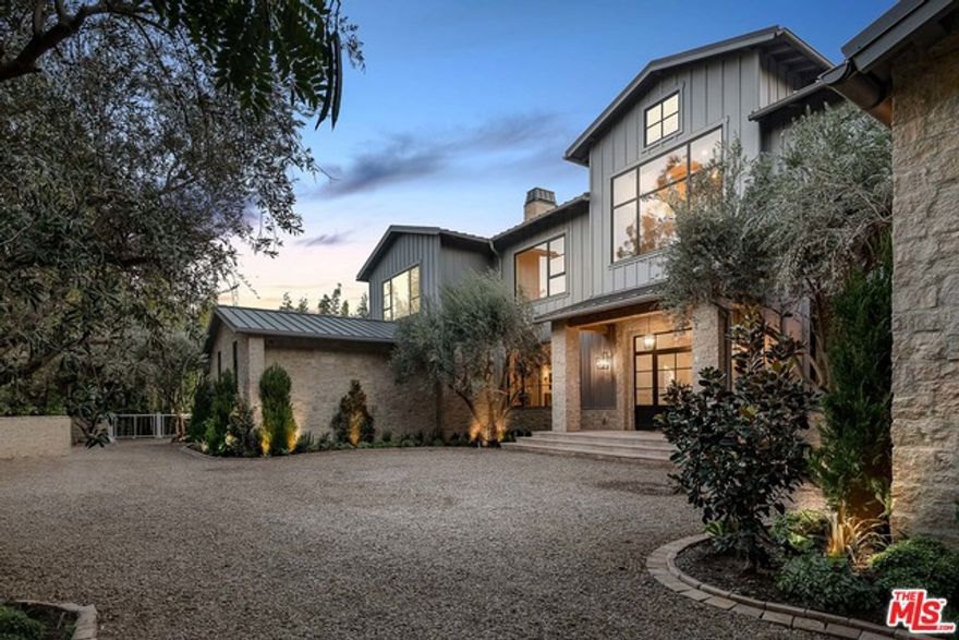 Secluded behind gates in an unrivaled Lower Mandeville Canyon setting, this Napa Valley-inspired Modern Farmhouse boasts a refined yet rustic ambiance upon an inimitable 36,000 plus square foot lot. By way of rich stone, reclaimed wood and marble features throughout, the captivating architectural seamlessly fuses contemporary details with the home's surrounding natural splendor, offering treetop and distant ocean vistas and a far-reaching equestrian-suited yard. Beyond the eight-bedroom main residence lies a covered loggia that leads out to the property's pool, spa, cabana and 924 square foot guest home, all of which are surrounded by verdant and manicured landscaping. Replete with a wine cellar, gym, elevator, media room, caterer's kitchen and spa bathroom inclusive of a dual vanity, massage room, sauna and steam room, this Philip Vertoch-designed home is the embodiment of a palatially pastoral retreat.