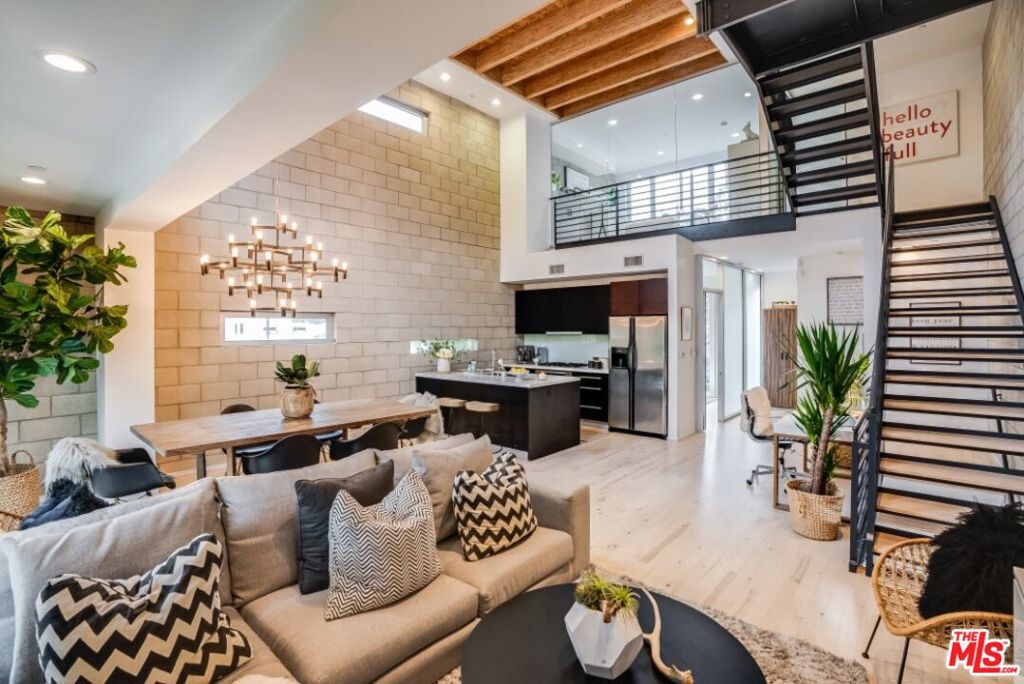 Welcome to this luxurious, fully furnished three-bedroom loft in a gated community across from world-famous Universal Studios where the Valley meets the Hollywood Hills, an iconic central location just moments to DTLA, studios, Hollywood, and the Westside. Inside, discover soaring ceilings and expansive windows that bathe the space in natural light. The open-concept layout features a state-of-the-art kitchen equipped with stainless-steel appliances, quartz countertops, and abundant cabinetry perfect for preparing home-cooked meals or having a private chef create an experience for a special occasion. The adjoining dining area comfortably accommodates guests, while the stylish living room provides a serene retreat for relaxation after a productive day. This four-story loft includes three impeccably designed bedrooms. The primary suite features a luxurious sunken tub, a separate shower, and a private patio overlooking the Hollywood Hills. The two additional bedrooms are also light-filled, one with an en-suite bathroom and the other with a modern bathroom near a private patio. The two-car garage is currently configured as a remote workspace with desks for up to five people, but can easily be used for parking. Additional amenities include central heating and air conditioning, high-speed Wi-Fi, and streaming services on three flat-screen TVs. An array of upscale dining options, vibrant bars, cozy cafes, and the Hollywood Bowl are all close by.