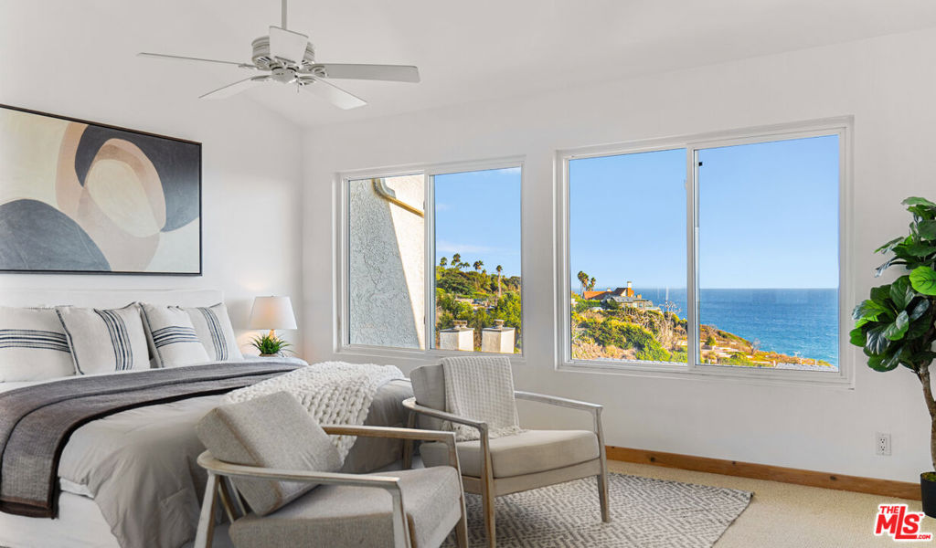This pristine townhome in the guard-gated enclave of Zuma Bay Villas on Point Dume offers sweeping ocean views, an impressive square footage, and quintessential coastal living. Located in the second row with unobstructed whitewater views of Westward Beach and beyond, the interior has been freshly updated with luxury finishes throughout, including wide-plank wood floors, brand new hardware, and a renovated kitchen. The entry level is flooded with natural light, and a large great room features plentiful space for a dining area and a large living room with a brick fireplace. Sliding glass doors lead onto a sun-soaked patio with a perfect Southern exposure where you can watch passing sea life and hear the breaking waves on the beaches below. An expansive kitchen is complete with custom cabinetry, Wolf appliances, Italian tile, a breakfast bar, and access to a garden patio perfect for outdoor grilling. Upstairs, the primary suite has panoramic ocean views through oversized windows and boasts a vaulted ceiling, newly installed carpet, three closets, including one large walk-in, and an en-suite bathroom. There are two additional well-sized bedrooms, a second full bathroom, and a powder room adjacent to the living areas. The unit has an attached two-car garage on the lower level with room for additional storage and a 100-bottle wine refrigerator. Zuma Bay Villas offers a peaceful atmosphere with resort-like amenities, including a heated saltwater pool and spa, a tennis court, clubhouse, plentiful guest parking, and 24-hour gated security. Residents enjoy the use of a private path to the surf and sand of Westward Beach, one of the area's deepest sandy beaches, and the iconic Sunset Restaurant. This Malibu residence provides both tranquility and convenience in one of Malibu's most sought-after neighborhoods, where sandy beaches, Point Dume Village, surf breaks, schools, and more are all at your fingertips.