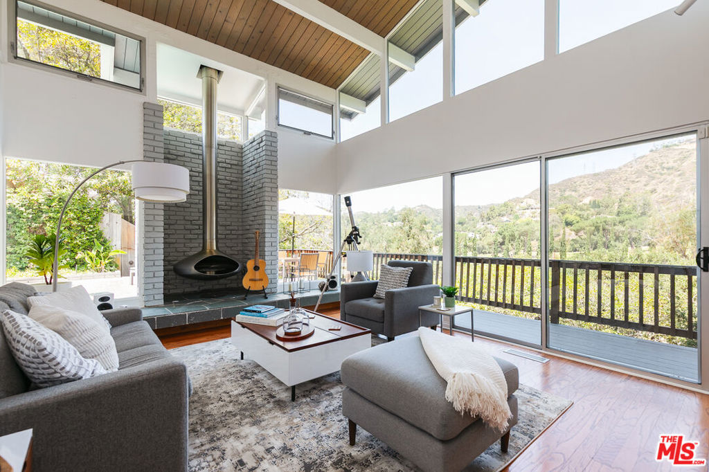 Perched on a rare street-to-street lot at the end of a quiet cul-de-sac, this meticulously updated architectural Mid-Century home offers panoramic views, striking privacy, and effortless indoor/outdoor living. Mature trees frame both sides of the property, creating a sense of seclusion, while preserving the home's sweeping, unobstructed vistas of the Chevy Chase golf course and surrounding canyon. Designed with intention and care, the layout features dual living rooms, each opening directly to the outdoors, blurring the lines between inside and out. A sculptural, custom-designed metal fireplace becomes the centerpiece of the main living space. Timeless Mid-Century lines, natural textures, and refined finishes are elevated by thoughtful contemporary updates throughout, bringing both character and comfort into perfect balance. Multiple decks and a sparkling pool offer your own private resort, ideal for lounging, entertaining, or simply soaking in the canyon breeze and starlit skies. A two-car garage with direct entry adds everyday convenience, while the hillside position floods the home with natural light all day long. Located just minutes from the Rose Bowl, Old Town Pasadena, and La Canada, this is a true California classic, reimagined for modern living with soul, style, and sweeping views.