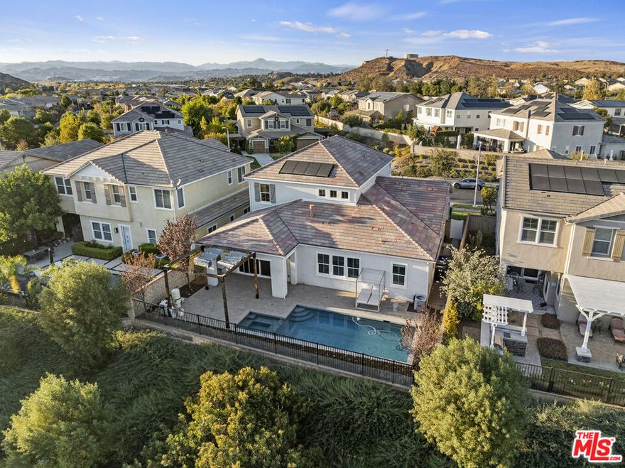 Spectacular 5 Bed, 4.5 Bath Gated Home in River Village Community with Stunning Views, Pool & Spa, and an Expansive Loft. The formal living and dining areas flow seamlessly into a spacious, light-filled family room with a custom fireplace and expansive windows showcasing the beautiful backyard views. The gourmet kitchen is a dream, highlighting stainless steel appliances, a double oven, granite countertops, a large center island, a butler's pantry with a wine fridge, and a walk-in pantry. The primary suite offers serene backyard views, an oversized walk-in closet, and a luxurious en suite bathroom with a soaking tub, walk-in shower, dual sinks, and a vanity area. A secondary bedroom includes its own en suite bath and walk-in closet. Spacious laundry room with ample cabinetry, shelving, and a utility sink. Upstairs, you'll find an expansive loft area filled with natural light, ideal for a media room or home office, along with three additional spacious bedrooms. One includes its own en suite bath, while the others share a full bathroom. All bedrooms offer ample closet space. The resort-like backyard features a California Room-style covered patio and a sparkling pool and spa all with stunning views, creating the perfect space for relaxation and entertaining. Community amenities include a gated entry, a sparkling pool, spa, kid's pool, BBQ area with a fireplace, clubhouse, parks, dog park, and scenic hiking and biking trails. Conveniently located with easy access to the 5 and 14 freeways via Newhall Ranch or Golden Valley. Close to top-rated schools, parks, hiking trails, Paseos, and a variety of restaurants and shopping. Don't miss this opportunity!!