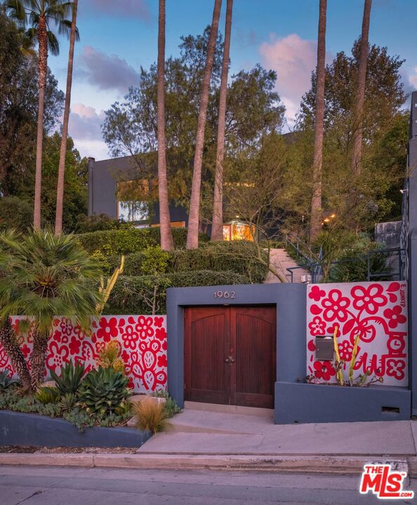 This architectural view home sits perched on a 12,371-square-foot promontory at the summit of Micheltorena, one of Silver Lake's most coveted streets. Multicolor sunsets dissolve behind the Griffith Observatory and the Hollywood Sign. The airy interior is a masterful study in volume and light. A sophisticated material palette defines the space, from the Terrazzo in the baths to the hardwood floors throughout to the modern kitchen with Caesarstone counters and polished concrete floors. The upper level is dedicated to three bedrooms, including a dramatic primary suite suspended over the city with a fully modern bath including a steam shower; plus a laundry room, craft room, and a recently completely remodeled second bath. Adding a layer of authentic Los Angeles creativity, the property features a street-facing custom mural by celebrated local artist Eric Junker. The line between inside and out vanishes as sliding doors open to the courtyard, pool, spa, and private ADU/pool house. Multiple decks and patios extend the living space, offering a variety of settings for both cozy moments and dramatic entertaining. A summer kitchen, complete with a BBQ and sink area, a shaded craft area currently used as a pottery studio, and a refreshing outdoor shower further enhance the compound. This seamless integration creates a perfect oasis for family living or hosting on any scale. This is a singular opportunity to own a home that feels torn from the screen, a private sanctuary that is both a definitive piece of architecture and the ultimate Los Angeles experience.