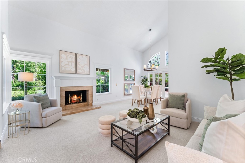 Some homes are well-designed. This one is beautifully elevated. At 4 Morning Breeze, timeless style meets everyday luxury. High ceilings and expansive windows draw the lush, park-like backyard inside—complete with a built-in BBQ, outdoor fireplace, and vibrant green lawn on a rare pie-shaped lot. French doors off the dining room create effortless indoor-outdoor flow.Two distinct living areas offer flexibility, while the family room features custom built-ins with soft under-cabinet lighting. The kitchen is a refined centerpiece, showcasing rich cherry wood cabinetry, white counter-tops, a center island, built-in refrigerator, and smart storage with pull-out drawers. Upstairs, the serene primary suite offers a custom walk-in closet and a spa-inspired bath with soaking tub and walk-in shower. Two additional bedrooms provide comfort and space.Located near Shady and Bommer Canyon trails and part of Irvine’s award-winning school district, this is a home that feels both graceful and grounded.