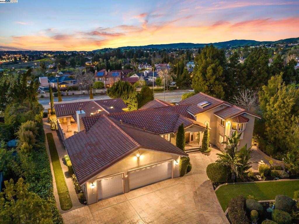 Magnificent Weibel custom home on half-acre premium lot offers sophisticated luxury in 4,598 sq. ft. Featuring 5 bedrooms, 3.5 baths, and 3-car epoxy-finished garage. Gourmet kitchen boasts custom cabinetry, granite surfaces, walk-in pantry, and new electric cooktop with breakfast nook capturing Bay views. Family room with vaulted ceilings and gas fireplace connects to covered patio. Primary suite includes walk-in closet, sitting area, and updated designer bath with dual sinks, glass shower and skylight. Four additional bedrooms with walk-in closets, one with private balcony. Formal living area features soaring ceilings and stained-glass windows; dining room showcases crystal chandelier and wet bar. Versatile in-law quarters with separate entrance includes kitchen, wine cellar, and full bath. Resort-style backyard with B&W speakers, stone pavers, panoramic views, mature landscaping and fountain pond. Premium features: Acacia hardwood, crown molding, dual-pane windows, fresh paint, updated secondary bath, efficient HVAC. Top-rated Weibel/Horner/Irvington schools. Minutes to 680/880, BART, and Silicon Valley tech companies.