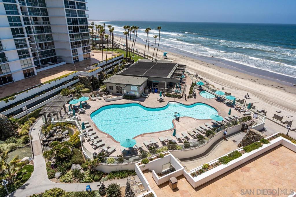 This corner unit is located on the 6th floor of Las Palmas Tower at the highly desirable Coronado Shores with views south to Mexico and across the bay to the Coronado Golf Course, Bay and Bridge. The spectacular arrangement of the sliding windows allows for an indoor/outdoor feeling as if you are perched right on the beach! Rise and shine to enjoy your coffee while watching the crashing ocean waves. A short stroll to the beach and beach club for sunset cocktails. This 3 bedroom, 3 bath unit has 2 primary bedroom suites with king beds and a third bedroom with 2 double beds. Gourment kitchen, designer quality furniture, luxury linens and 2 car garage parking space.