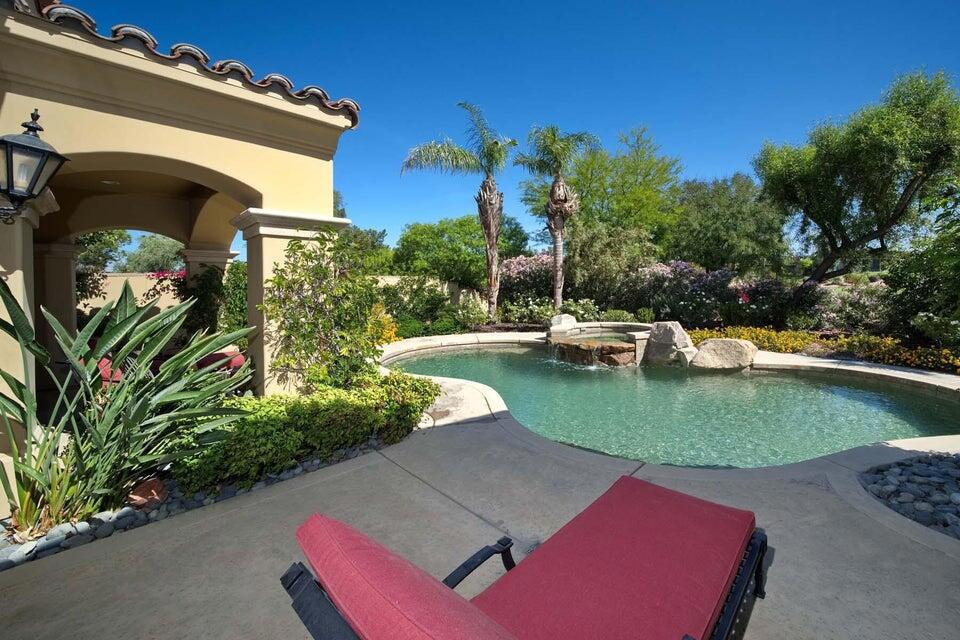 This beautiful home inside Toscana Country Club offers spacious desert living on a generous corner lot. New, mature landscaping provides ultimate privacy while still allowing for spectacular views of the mountains and Hole 4's Green of the Jack Nicklaus Signature North Golf Course. Upgrades to this home include fresh interior and exterior paint, newer HVAC, new pool equipment, and updated furniture. Inside, the two sets of sliding glass doors blend indoor-outdoor living areas, while the wetbar provides butted-glass windows allowing for panoramic views. The gourmet kitchen offers the perfect entertainment prep space, complete with ample cabinetry, island, breakfast bar peninsula, granite counterops, and SubZero Wolf stainless steel appliances. For casual dining, a breakfast nook is accompanied by a dry bar perfect for morning coffee. Retreat to the master bedroom,which features space to lounge, and sliding glass doors to a private patio overlooking the pool and spa. The grand en-suite has His & Hers sinks with separate vanity, enormous soaking tub, walk-in shower, and His & Hers closet entries. Guests can relax in the main-home guest room, or a more secluded guest room with access to a private patio in the courtyard.
