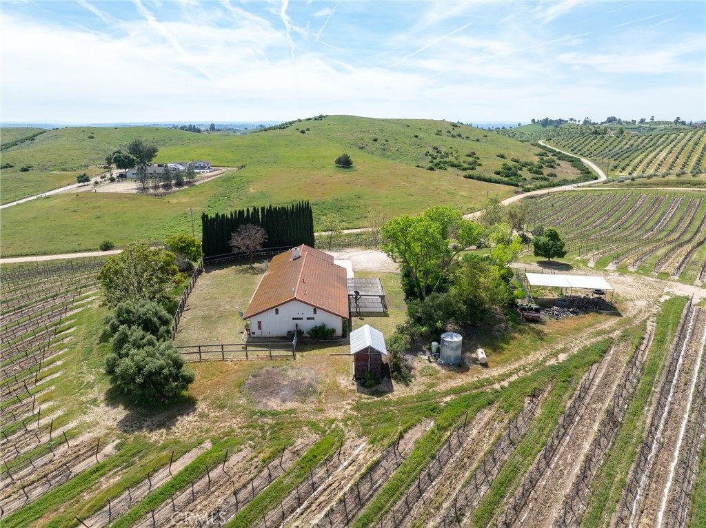 Enjoy the best of Paso Robles wine country living with this peaceful and private 14-acre property, offering scenic views and relaxed rural charm. The 1,902± sq.ft. single-level home features 4 bedrooms, 2 bathrooms, and a bonus room—perfect as a home office, guest space, or hobby room. The open floor plan includes a spacious kitchen with ample storage, a welcoming dining area, and a cozy living room with a wood-burning fireplace and large windows that frame breathtaking vineyard and valley views.
Professionally managed and low-maintenance, the 11± acres of premium Cabernet Sauvignon vines offer passive income potential, with an optional grape contract available through a luxury Napa wine company. Strong projected 2025 crop yields between 4-5 TPA offer great potential income. Enjoy the perks of vineyard ownership without the labor—ideal for investors or those seeking a tranquil home in wine country.
The setting is serene and inspiring, surrounded by lovely neighbors including a lavender farm, equestrian ranch, olive grove, and fruit orchard. The property offers abundant space for animals, gardens, and future expansion—whether you envision an additional home, ADU, or workshop. Interested in removing some or all of the vineyard? No problem!
Vacation rental and 1031 exchange eligible, this is a rare opportunity to own a turnkey vineyard lifestyle property in a desirable Paso Robles location.