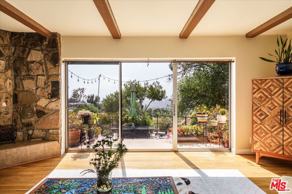 One of the best priced homes in Tujunga! Set on nearly 3 acres, this 1936 Spanish Hacienda offers the rare combination of privacy, expansive land, and breathtaking panoramic views. Ready for the vision of a new owner, the timeless charm is undeniable. The inviting living room features wood-beamed ceilings, hardwood floors, a pair of stunning stained glass iris flower windows original to the home and a dramatic flagstone fireplace. Glass sliders open to an extensive patio perfect for sultry summer evenings and stunning sunsets. The thoughtfully designed floor plan includes a kitchen that blends vintage charm with everyday functionality, featuring tiled countertops and ample cabinetry, a spacious laundry room, a formal dining room and a bar area adorned with a Lady of Guadalupe ceramic tile mural. Upstairs you will find the primary with generous closet space and en-suite bathroom tiled in sunny yellow vintage tile and two additional bedrooms and a vintage blushed tiled bathroom. Outside, your own private park awaits. The terraced gardens are highlighted by a stream, California River Rock embankments, a large pond, and native plants that attract local wildlife. It's the perfect place to enjoy a peaceful stroll, outdoor yoga, or gardening. Additional highlights include an attached two-car garage and a framed original blueprint of the home proudly displayed inside. A rare offering for lovers of nature, architecture, and privacy.