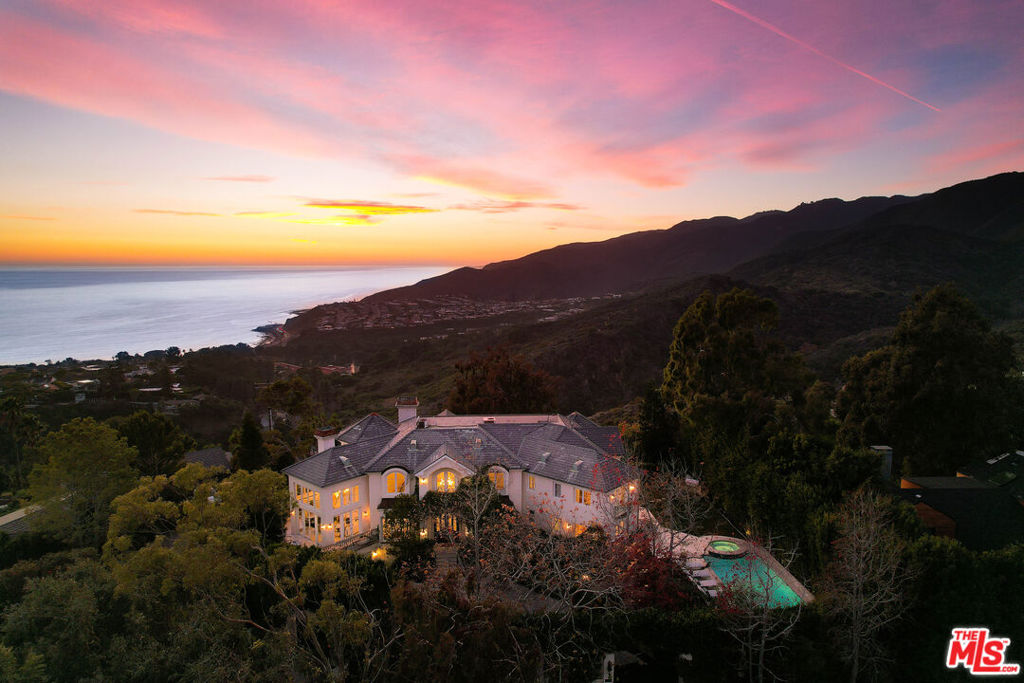 Fall in love with the visual symphony that is the prestigious Paseo Miramar. Perched on top of an exclusive Pacific Palisades community, this custom built home stands alone in quality and design featuring unparalleled ocean, mountain and city views. Behind the dual gates you transport to a serene French Riviera setting with privacy and security as the thesis of this masterpiece. Step inside to take in the scale of this spacious 6 bedroom 7000+ sq ft estate with soaring wood beamed ceilings and walls of windows drawing your eyes to the glimmering Pacific Ocean. With a true connection to nature, the Paseo Miramar evokes all of the senses of home, comfort and function. Offering space for everyone inside and out with all a modern buyer desires including a one of a kind home office, home theater screening room with bar, gym and turret style den off of the primary suite with multiple cozy fireplaces. Newly redesigned chefs kitchen with designer natural stone Taj Mahal counters, massive center island and bar seating is the perfect place to create and delight with a spacious breakfast room surrounded with textured ocean and mountain views. Enjoy the comforts of home in your primary suite with vaulted ceilings with breathtaking views off the private veranda. Enjoy picturesque scenes throughout the home with several balconies and terraces to take in beautiful ocean and mountain landscapes. Step outside to your own oasis with towering privacy hedges, mature landscaping and meandering paths of manicured gardens. Enjoy the best of Southern California living in your own resort style pool and escape from the day to day in this peaceful environment. Privacy abounds this palatial estate with circular driveway and impressive motor court. Exploration and adventure awaits outside of your gates with world class hiking steps away and answer the call of Californias most famous beaches just moments from your front door. Away from everything yet so close to it all including the Palisades Village, iconic beaches and some of the most popular destinations Los Angeles has to offer.