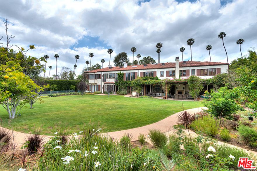 Distinguished 10,000+ square foot Mediterranean style residence designed by architect Peter Choate, available for only the second time in over 60 years. Extremely rare double lot of approx. 1.2 private, park-like acres in the heart of the Beverly Hills flats. Property includes a guest house, swimming pool, lighted sports court, large gated courtyard entry with magnificent trees and fountains. Open plan interior with lustrous wood floors and wide views onto tranquil gardens. Gorgeous exposed-beam living room; formal dining with coffered wood ceiling; handsome great room with dramatic double-height truss ceiling, fireplace, wet bar, loft. Entertainer's kitchen has breakfast area, center island, stainless appliances, and butler's pantry. Private screening room has hand-painted ceiling. Glamorous master with fireplace, palatial baths, walk-in closets. Gym with private bath and sauna. Majestic yard has fruit trees, rose garden, broad lawn, and flowering vines. A masterpiece of refined style