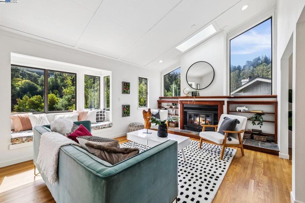 The East Bay hills are the backdrop to peaceful California living in this upgraded 3+BD/2.5BA contemporary that lives large with multiple decks, patios, and level yard areas. Sunny and bright, the 2331 SQFT home offers fabulous indoor/outdoor living in its generous floorplan. Entertain friends or cozy up with family in the living room, featuring a high ceiling with skylight, a fireplace, built-ins, windows galore, sliding glass door to a deck, and hardwood floors that span into the adjacent dining room and kitchen. The kitchen has been renovated for style and ease with new appliances and cabinets, custom pantry, and breakfast bar. French doors from the dining room to the deck let you dine indoors or out with hillside views. The upper level is complete with a powder room and large office alcove. Downstairs find three generous bedrooms, each with doors to another deck and the large backyard. The primary offers a new ensuite bath with dual vanity, and two other bedrooms share a full bath. On the lower level, relax in the family room or step out to the flat backyard where you can unwind and play surrounded by roses and fruit trees. Situated at the end of the coveted railroad walking trail to vibrant Montclair Village, & all the delights of the East Bay regional park system.