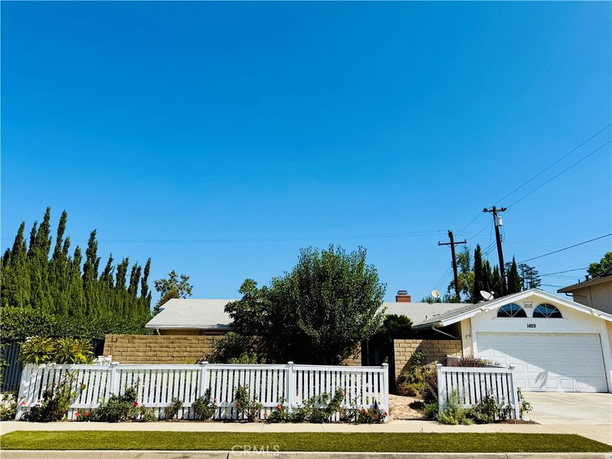 This charming single-story home, situated on a desirable corner lot in the City of Orange, offers exceptional curb appeal and numerous desirable features. The property boasts three bedrooms, two bathrooms, a two-car garage, driveway space for 3 cars and air conditioning. Separate private and gated RV or boat storage is included and located along street side of this corner property. 

The spacious eat-in kitchen is a highlight, equipped with modern conveniences, features an oversized skylight, a garden window, ample dining space, a sliding glass door to the backyard, and a convenient side entrance. The primary bedroom suite includes a private bathroom, enhancing privacy and comfort. The two secondary bedrooms are light and bright, perfect for bedrooms, den or office space.  

Landscaping is professionally installed, featuring a sprinkler system and a variety of mature fruit trees (avocado, mango, pomegranate) and flowering plants, including roses. The front yard is beautifully landscaped and enclosed by a white picket fence, while a private front patio offers additional outdoor enjoyment. The expansive backyard provides significant outdoor living space, complete with two storage sheds and raised garden beds ideal for cultivating your own fruits, vegetables, herbs & flowers. Additional landscaping features include a dry creek bed, thoughtfully placed planting beds, and flowering vines adorning the backyard walls.

This exceptional property is offered at a competitive lease price and presents an excellent opportunity for a qualified Tenant to establish their new home. Drive by only while on Coming Soon.