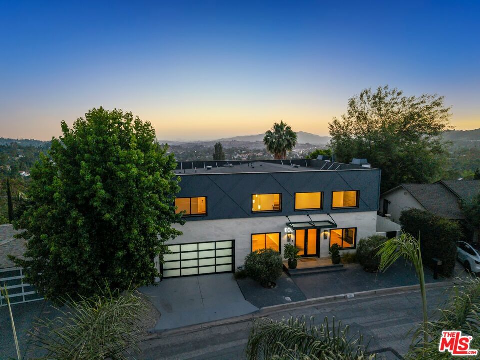 Perched in the San Rafael Hills, this reinvented 1948 modern home delivers space, style, and panoramic viewsstretching from Downtown LA to the San Gabriels. Fully renovated in 2021, it spans over 4,000 square feet with 5 bedrooms and 6 baths, including four en-suites and three with private balconies overlooking the city. The main floor is bold and open, featuring dramatic 20-foot ceilings, a statement wet bar, and a guest suite. The kitchen is built to host, with premium appliances, a wine fridge, and an oversized waterfall island offering plenty of storage and seating. Upstairs, the primary suite feels like a retreat with a spa-style bath and a fully built-out closet. Downstairs adds flexibility with a large family room, dry bar, direct yard access, and a bonus bedroom that works perfectly as a gym or office. There's even a dedicated dog-wash area. The outdoor space continues the vibe with a large view deck, terraced gardens, a bocce court, and extra storage. All just minutes from the Rose Bowl, Highland Park, Eagle Rock, Old Town Pasadena, and downtown. This is California living elevated.